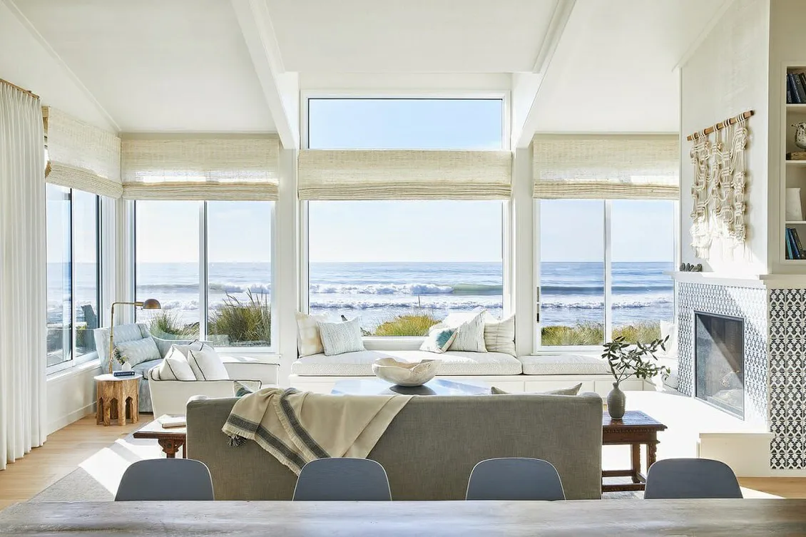 ​A Coastal Grandma Style Home living room featuring luxury sofas, solid wood center tables, and wooden side tables.