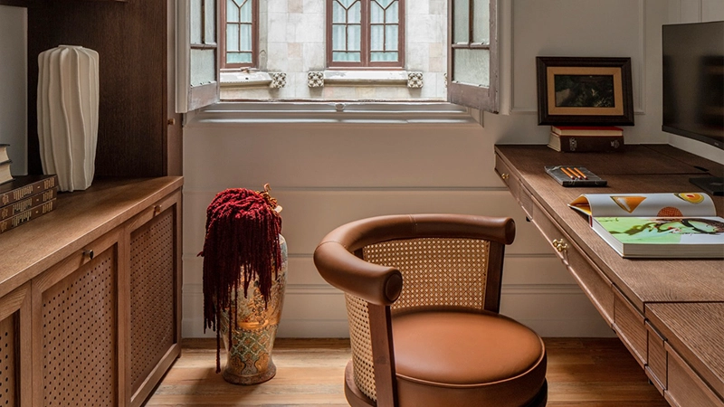 Projects Inigo Iriarte partilha 2 Refined desk space, at San Sebastián, designed by Iñigo Iriarte, highlighting the George dining chair in leather upholstery, smoked walnut wood, and a handcrafted rattan backrest.