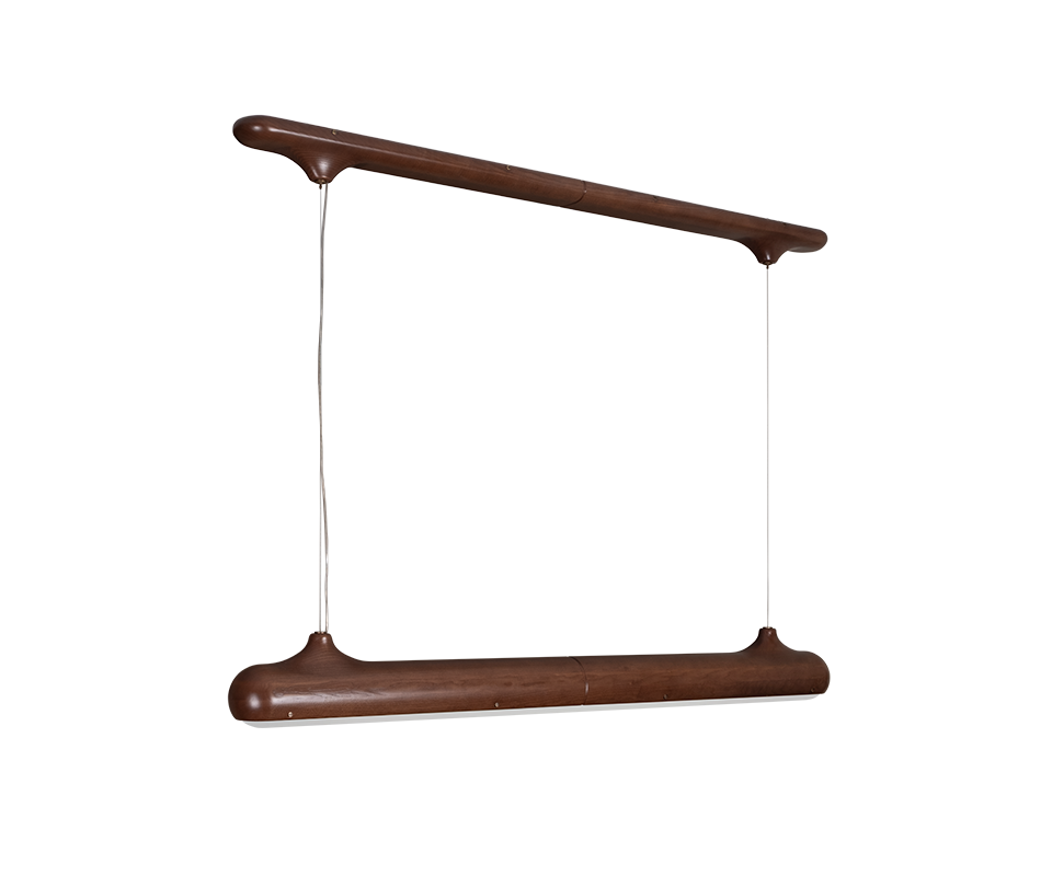 Bruce Suspension Lamp Bruce suspension lamp by Wood Tailors Club in smoked walnut wood, seen from a three-quarter angle. A long, rounded wooden canopy bar hangs above a matching linear luminaire, joined by two thin cables attached to tapered, organic-shaped end fittings.