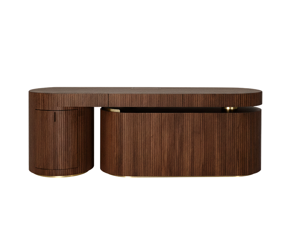 Gifford desk by Wood Tailors Club in smoked walnut wood. Front view of the desk in a linear, closed configuration. The lower dark wood shelf module is retracted parallel to the main dark wood desktop, with its curved, closed fluted side facing forward, to the right of the fluted dark wood cabinet on the far left. Polished brass leg details.