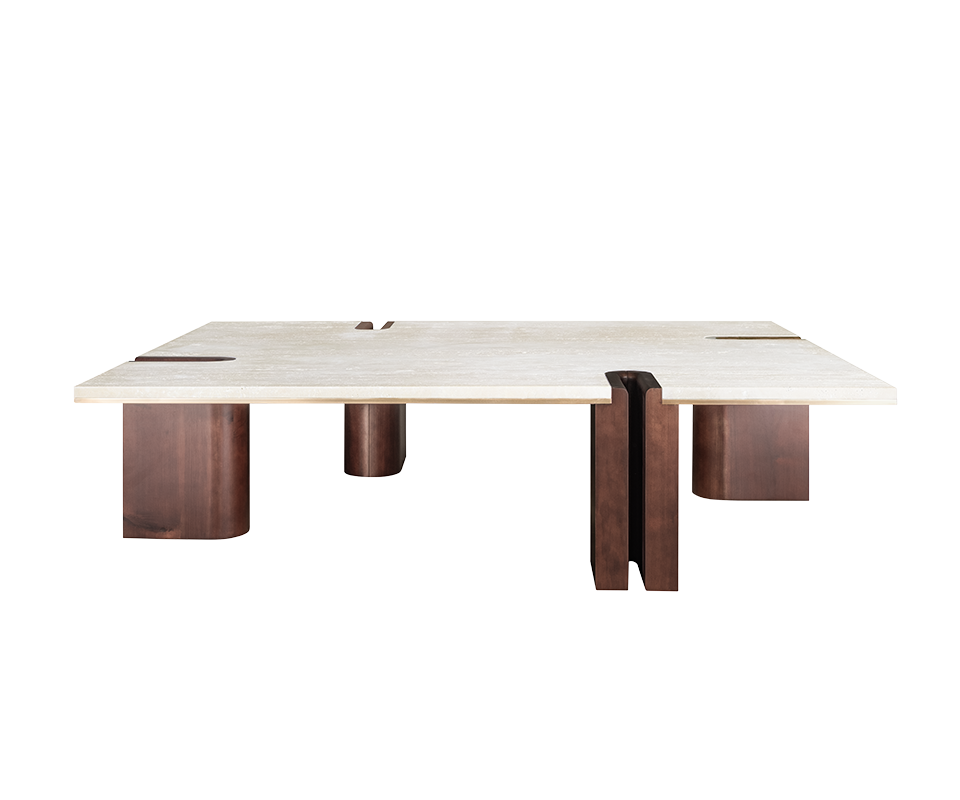 A wide front view of the Grenville Center Table featuring a thick, rectangular cream travertine top. The structure consists of four chunky, asymmetrical legs made of dark smoked walnut wood. One leg features a distinctive vertical U-shaped cutout that notches into the stone top, revealing a thin brushed brass inlay along the edge.