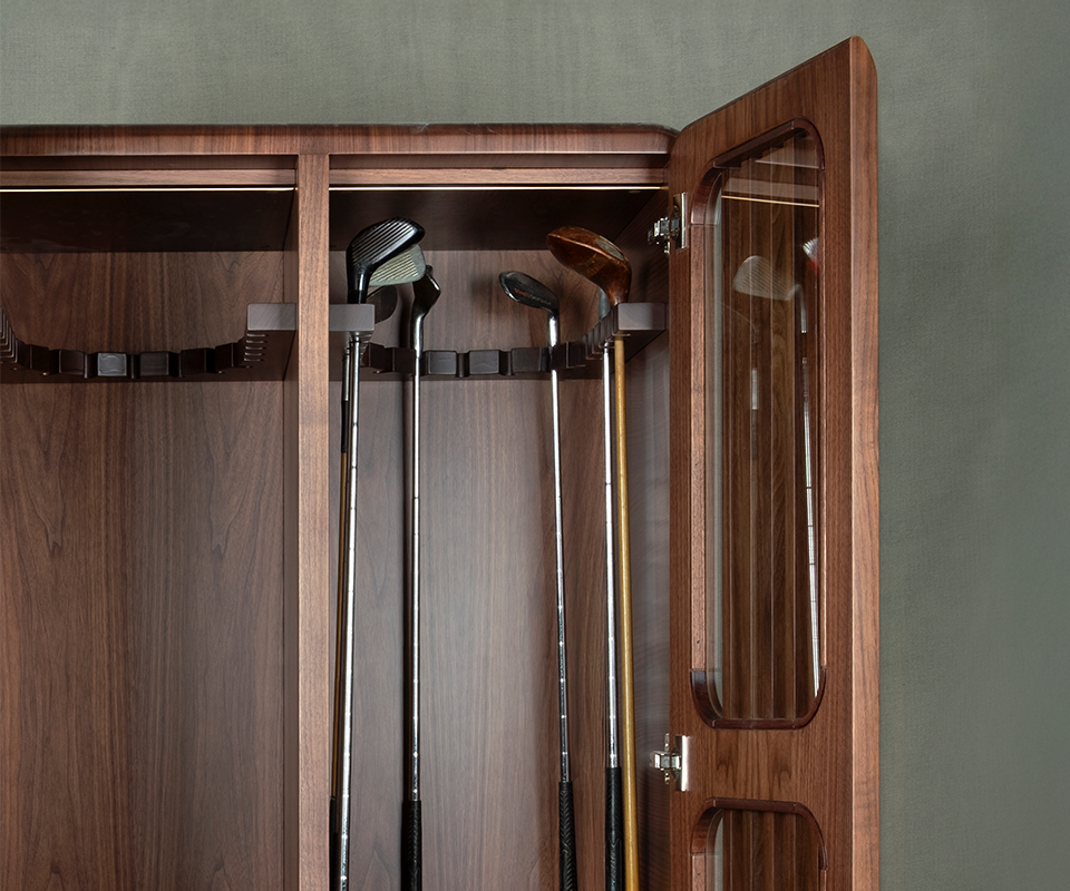 A detailed view of the upper interior of the smoked walnut Kennedy Golf Locker, showing various golf clubs (drivers and irons) securely resting in the custom-carved wooden hanging system.