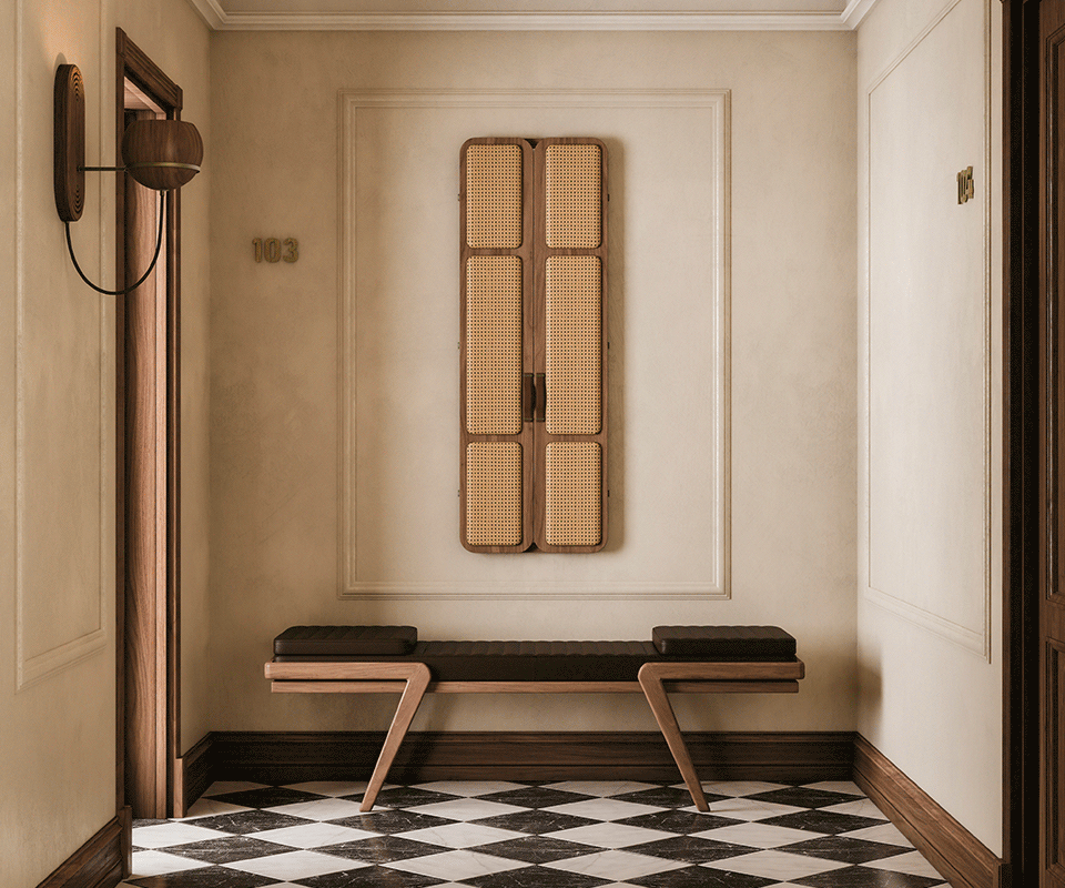 Tom folding mirror opening and closing in a hotel corridor, featuring upholstered doors, leather handles, and an interior mirror. The floor displays a diamond checker pattern. Below the mirror is the Milton Bench, with an oak structure and leather seat. Flaming wall lamp and Faraday wall lamp in smoked walnut wood complete the setting.